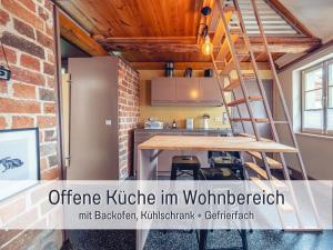 an open kitchen with a staircase in a tiny house at Molly Moll - Mini Ferienhaus in Kyritz, einer charmanten Stadt im Herzen von Brandenburg in Kyritz +33 photos