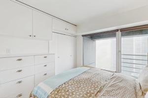 a white bedroom with a bed and a window at Pike Place Pearl in Seattle