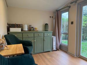 a living room with a green cabinet and a window at Tiny home OR Chalet - with toilet & shower room in separate outbuilding in Nottingham