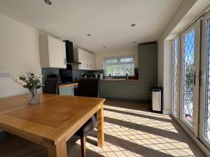 a kitchen and living room with a wooden table at 2 Bedroom Bungalow by the Arches in Earlestown