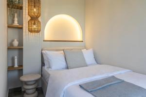 a small bedroom with a bed and a stool at Cavo Dio 7 - Beachfront bliss - Cozy Apt Pool Sunset in Káto Dhiminión