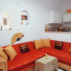 a red couch in a living room with a table at Bungalow kantaoui Sousse in Hammam Sousse
