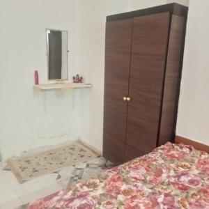 a bedroom with a bed and a dresser and a mirror at Bungalow kantaoui Sousse in Hammam Sousse