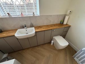 a bathroom with a sink and a toilet at 2 Bedroom Bungalow by the Arches in Earlestown