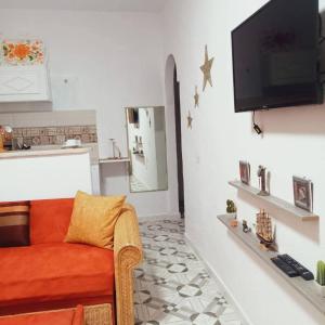 a living room with a couch and a flat screen tv at Bungalow kantaoui Sousse in Hammam Sousse