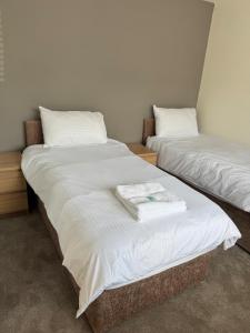 two beds sitting next to each other in a room at 2 Bedroom Bungalow by the Arches in Earlestown
