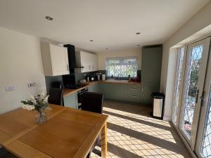 a kitchen with a wooden table and a dining room at 2 Bedroom Bungalow by the Arches in Earlestown +3 photos