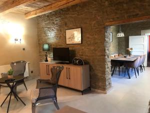 a living room with a tv and a table and chairs at Apartmány Za Zvončekom in Vydrná