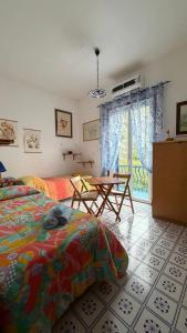a bedroom with a bed and a table and a window at La casa del Capitano, l'uomo e il mare ... in Lipari