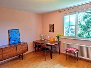 a room with a desk and a table and a window at rest at last in Geneva