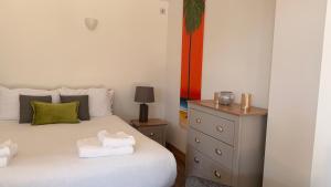 a bedroom with a bed and a dresser with towels on it at Converted Barn Studio with Private En-Suite in Horspath