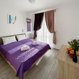 a bedroom with a purple bed and a window at Villa ARINA - Apartments 20 m from Beach, Tucepi in Tučepi