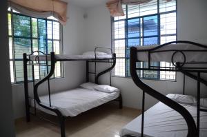 a room with two bunk beds and two windows at El Algarrobo in Tocaima