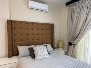 a bed with a large headboard in a bedroom at Luxstay in Nelspruit