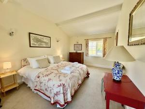 a bedroom with a bed and a table with a lamp at Blackmoor View Cottage in Sherborne