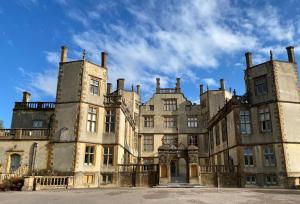 an old castle with two towers on top of it at Blackmoor View Cottage in Sherborne