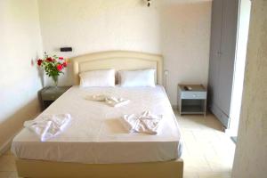 a bedroom with a large white bed with two silver towels at Mark Hotel in Heraklio