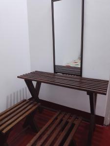 a wooden bench sitting in a room with a mirror at Ruwanthera Eco Resort in Ruwanwella