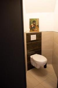 a bathroom with a toilet and a painting on the wall at Alte Schreinerei in Steffeln +2 photos