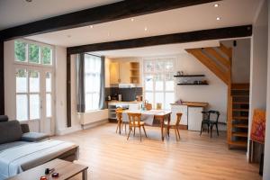 a living room with a table and chairs and a kitchen at Alte Schreinerei in Steffeln