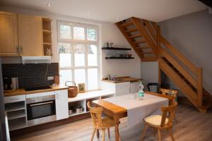 a kitchen with a table and chairs and a staircase at Alte Schreinerei in Steffeln