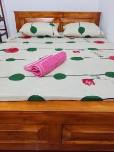 a bed with a pink towel laying on it at Ruwanthera Eco Resort in Ruwanwella