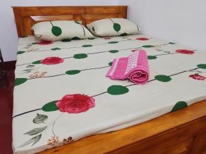 a bed with flowers and a pink towel on it at Ruwanthera Eco Resort in Ruwanwella