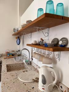 a kitchen with wooden shelves on the wall at The Happinesst بيت فرح in Anfah +15 photos