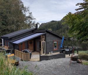 a small cabin with a porch and a deck at Rasteplassen in Stordalen