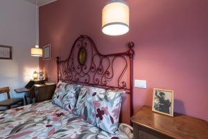 a bedroom with a large bed and a pink wall at RoncoBèrtolo R&B in Loiano