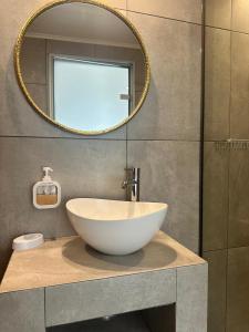 a bathroom with a white bowl sink and a mirror at Anemone Suites in Georgioupolis
