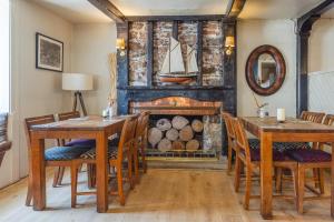 a dining room with a fireplace and wooden tables and chairs at Bickley Mill Inn in Newton Abbot +39 photos