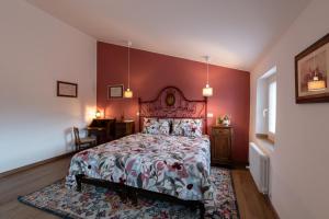 a bedroom with a large bed with red walls at RoncoBèrtolo R&B in Loiano