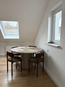 a table in a room with chairs and a window at Urlaub-Im-Erletal in Schleusingen +8 photos