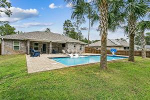 a house with a swimming pool in a yard at Lil Breezy in Navarre