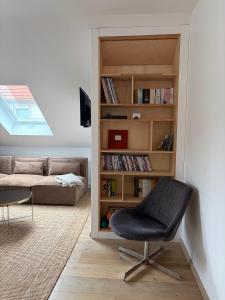 a living room with a chair and a book shelf at Urlaub-Im-Erletal in Schleusingen