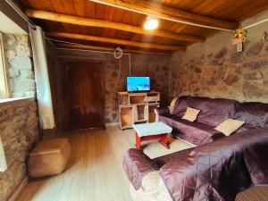 a living room with a couch and a tv at Casa Rumiwillka in Urubamba +11 photos