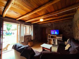 a living room with a couch and a tv at Casa Rumiwillka in Urubamba