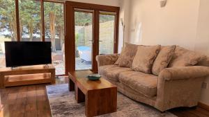 a living room with a couch and a flat screen tv at Converted Barn Studio with Private En-Suite in Horspath +15 photos