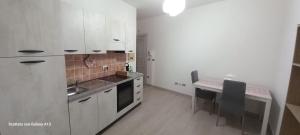 a kitchen with white cabinets and a table with chairs at Kylix Home in Campobasso