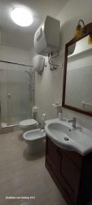 a bathroom with a toilet and a sink and a mirror at Kylix Home in Campobasso