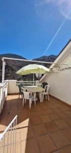 a patio with a table and chairs and an umbrella at Studio décor chalet jusqu'à 6 couchages in Fontpédrouse
