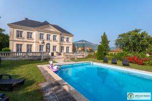 a swimming pool in front of a house at Chambres d hôtes dans maison bourgeoise Douce France in Millau