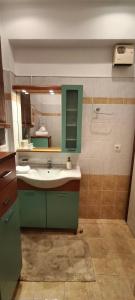 a bathroom with a green sink and a mirror at Sea & Mountain View Apartment in Chalkida +60 photos