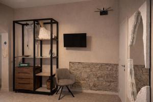 a room with a chair and a television on a wall at Sant'Agostino in Pizzo