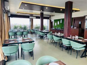 a dining room with tables and chairs in a restaurant at Sangam Hotel in Kiul