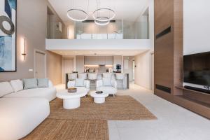 a living room with a white couch and a tv at Villa Erifyli in Aghia Marina