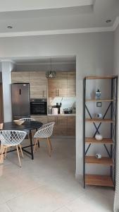a kitchen with a table and chairs and a refrigerator at Capital Apartment kilkis in Kilkis