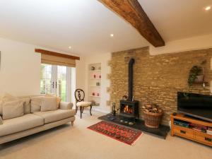 a living room with a couch and a fireplace at Stanbridge Cottage in Malmesbury
