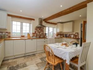 a kitchen with a table and chairs in a kitchen at Stanbridge Cottage in Malmesbury